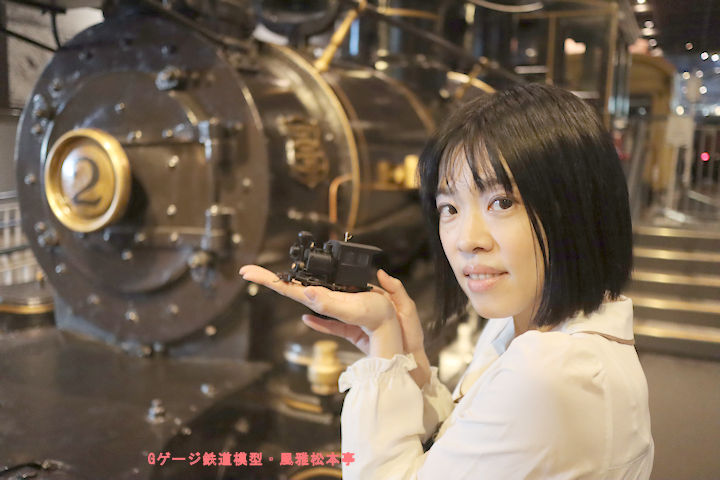 ポーター(H.K.Porter)製蒸気機関車の前で、ポーター製亀の子機関車を持つアイドル。